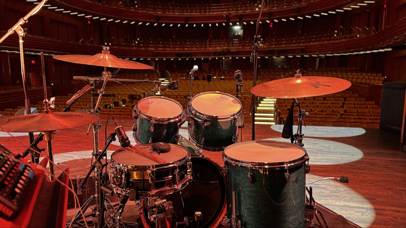 Emanuel Lozada's drum kit set on a theater stage